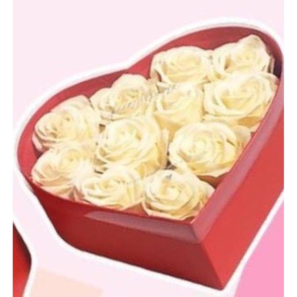 Roses crème dans une boîte en forme de cœur rouge
